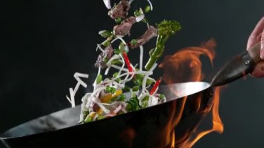 Super slow motion of flying asian beef meat with vegetable and noodles. Filmed on high speed cinema camera, 1000 fps. Speed ramp effect.