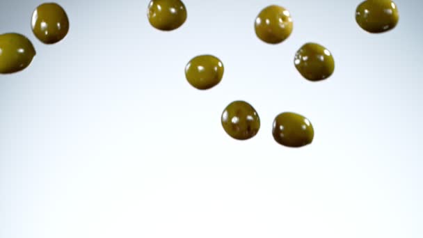Mouvement Super Lent Des Olives Vertes Tombant Sur Fond Blanc — Video