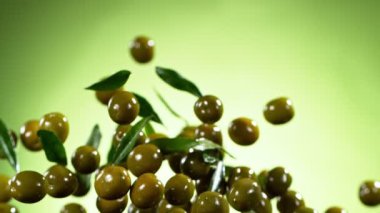 Super slow motion of flying green olives on green background. Filmed on high speed cinema camera, 1000fps.