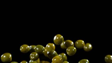 Siyah arka planda uçan yeşil zeytinlerin süper yavaş çekimi. Yüksek hızlı sinema kamerası, 1000fps.