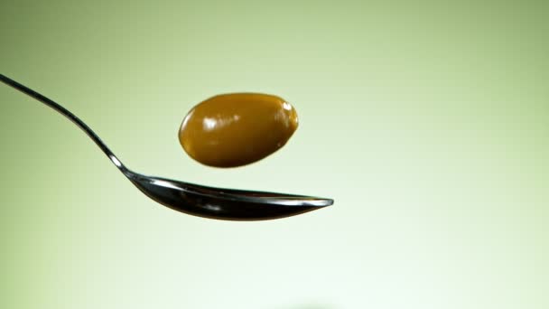 Super Slow Motion Falling Olive Spoon Splashing Filmed High Speed — Stock Video