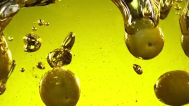 Super slow motion of falling green olives into oil. Filmed on high speed cinema camera, 1000fps.