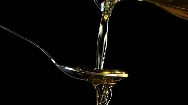 大杯橄榄油倒在金属勺上的镜头 被隔离在黑色背景下 — 图库照片
