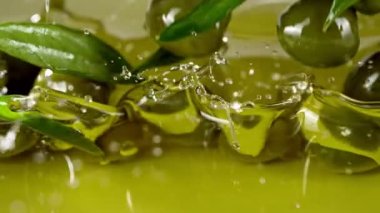 Yeşil zeytinlerin yağın içine düşmesi süper yavaş bir hareket. Yüksek hızlı sinema kamerası, 1000fps.