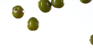 Yeşil zeytinlerin yağın içine düşmesi süper yavaş bir hareket. Yüksek hızlı sinema kamerası, 1000fps.