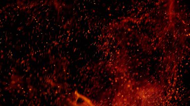 Ateş siyah zemin üzerinde parçacıklar gibi uçuşan kıvılcımlar. Soyut arkaplan.