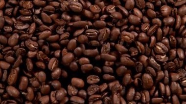 Siyah arka planda kahve çekirdeklerini üflemenin süper yavaş çekimi. Yüksek hızlı sinema kamerası, 1000 fps..