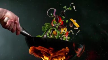 Süper yavaş uçan somon eti ve tavadan Asya sebzesi. Yüksek hızlı sinema kamerası, 1000 fps. Hız rampası etkisi.