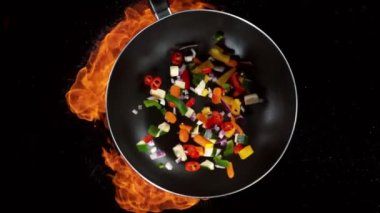 Ateşli tavadan dilimlenmiş sebze parçalarının süper yavaş çekimleri. Yüksek hızlı sinema kamerası, 1000 fps. Hız rampası etkisi.