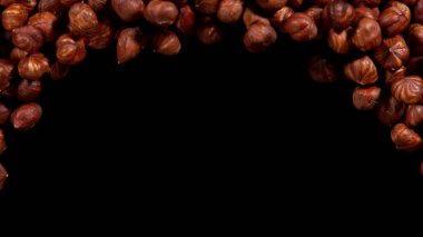 Fındıklar siyah arkaplanda izole edilmiş, üst görünümde ise telif alanı var. Karanlık masada izole edilmiş çeşitli fındıklar..