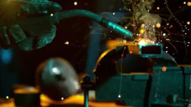 Atölyede kaynakçının çok yavaş çalışması. Detay atışı, düşük odaklanma derinliği. Yüksek Hız Sinema Kamerasında, 1000 fp..