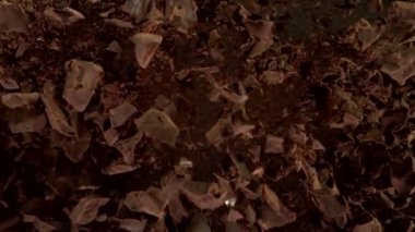 Uçan Çiğ Çikolata Parçalarının Aşırı Yavaş Hareketi ve Hızlı Etkisi. Yüksek Hız Sinema Kamerasında Çekim.
