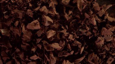 Çiğ çikolata parçalarından oluşan uçan grubun hareketsiz hareketi. Siyah arkaplanda izole