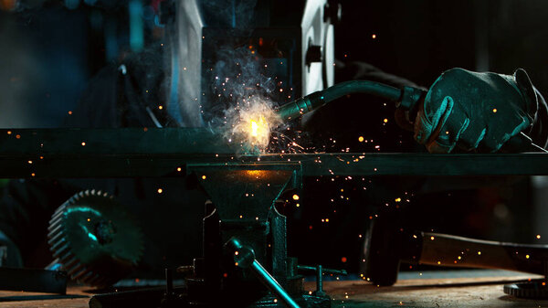 Welder welding technical steel. Industrial steel welder in factory.