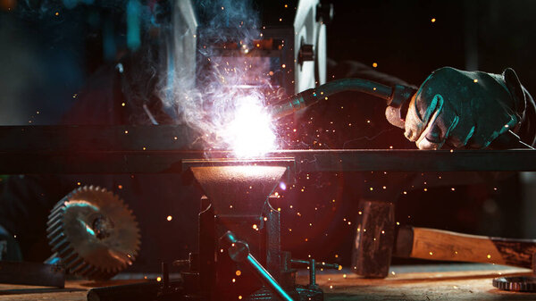 Welder welding technical steel. Industrial steel welder in factory.