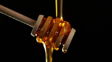 Siyah arka planda bal damlatan balın süper yavaş akışı. Yüksek hızlı sinema kamerası, 1000 fps..