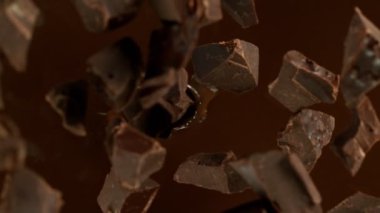 Erimiş çikolataya Düşen Çikolata Parçalarının Süper Yavaş Hareketi. Yüksek Hız Sinema Kamerası, 1000fps.