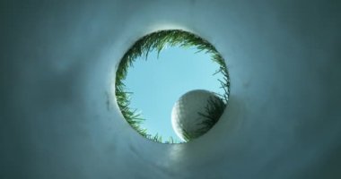 Çukura düşen golf topunun süper yavaş çekimi. Eşsiz bakış açısı. Yüksek hızlı sinema kamerası, 1000fps.