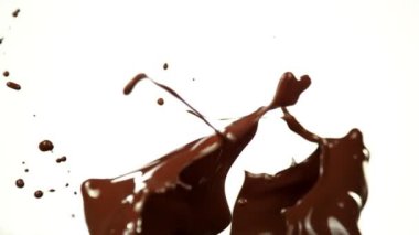 Super Slow Motion of Melted Chocolate Splashing in Waves shapes. Isolated on White Background. Filmed on High Speed Cinema Camera in 4k, 1000fps. Speed Ramp Effect.