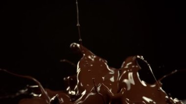 Super Slow Motion of Melted Chocolate Splashing in Waves shapes. Isolated on Black Background. Filmed on High Speed Cinema Camera in 4k, 1000fps.