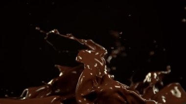 Super Slow Motion of Melted Chocolate Splashing in Waves shapes. Isolated on Black Background. Filmed on High Speed Cinema Camera in 4k, 1000fps.