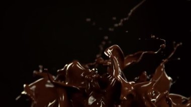 Super Slow Motion of Melted Chocolate Splashing in Waves shapes. Isolated on Black Background. Filmed on High Speed Cinema Camera in 4k, 1000fps.