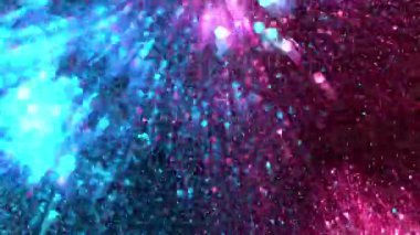 Super slow motion of glittering neon particles on black background. Shallow depth of focus. Abstract shimmering background with glows.