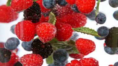 Su altında dönen dutların süper yavaş çekimi, beyaz arka plan. Yüksek hızlı sinema kamerası, 1000 fps..