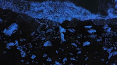 Aerial panoramic footage of Icelandic Diamond Beach. Top view above black volcanic beach with icebergs, shot in evening.
