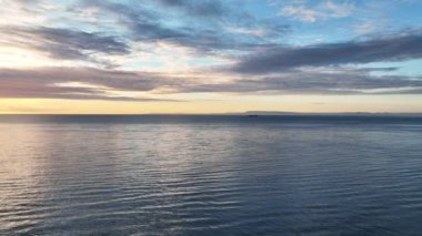 Aerial panoramic footage of ocean waves in sunset with cruiser on background. Beautiful sunset landscape with horizon.
