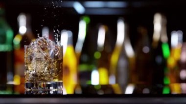 Buz küpünün viski içkisine dönüşmesi çok yavaş bir hareket, kamera hareketi. Hız rampası etkisi. Yüksek hızlı sinema kamerası, 1000 fps.