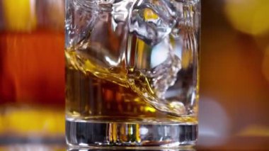 Buz küpünün viski içkisine dönüşmesi çok yavaş bir hareket, kamera hareketi. Hız rampası etkisi. Yüksek hızlı sinema kamerası, 1000 fps.