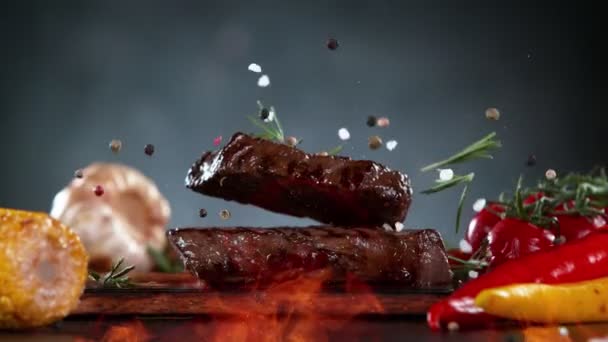 Flying Pieces Grilled Beef Steaks Spices Falling Table Fire Filmed — Wideo stockowe