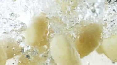 Super slow motion of falling potatoes gnocchi into water. Filmed on high speed cinema camera, 1000 fps. Speed ramp effect.