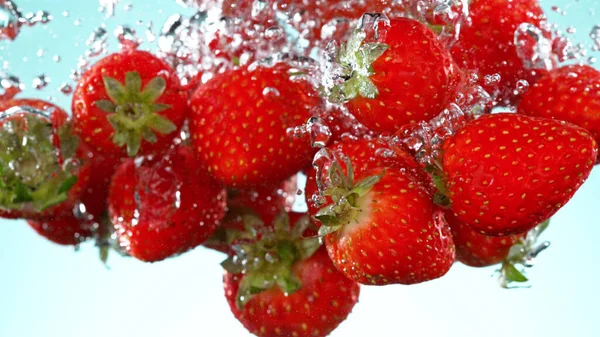 草莓片落在水下的白色背景 新鲜多汁的背景 — 图库照片