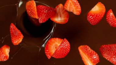 Erimiş çikolatanın içine düşen çileğin süper yavaş çekimi. Sinema, yüksek hızlı kamera, 1000fps.