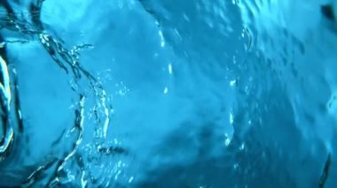 Su yüzeyini dalgalı şekillerde karıştırmak için süper yavaş çekim. Yüksek hızlı sinema kamerası, 1000 fps..
