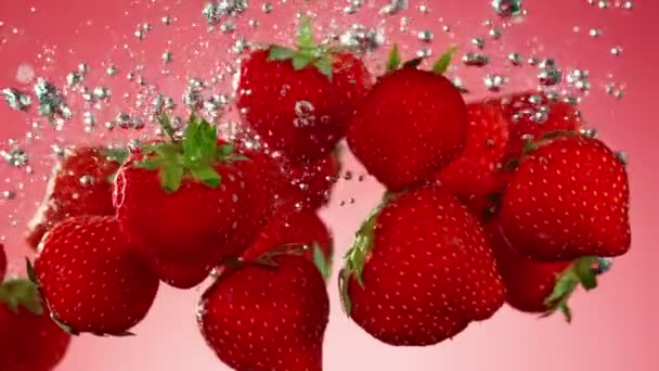 Super Langzame Beweging Van Vallende Aardbeien Water Rode Achtergrond Gefilmd — Stockvideo