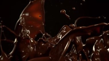 Super Slow Motion of Melted Chocolate Splashing in Waves shapes. Isolated on Black Background. Filmed on High Speed Cinema Camera in 4k, 1000fps.