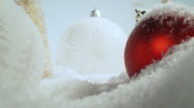 Noel cam toplarıyla yağan karın süper yavaş çekimi. Kaydırma üzerinde kamera hareketi. Yüksek hızlı sinema kamerası, 800 fps..