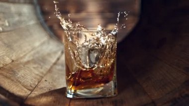 Viski bardağına düşen buz küpünün süper yavaş çekimi. Eski ahşap fıçıya yerleştirilmiş. Yüksek hızlı sinema kamerasıyla çekildi, 1000fps. Nihai yaratıcı kompozisyon.