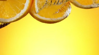 Super slow motion of falling orange slices into water. Filmed on high speed cinema camera, 1000 fps.