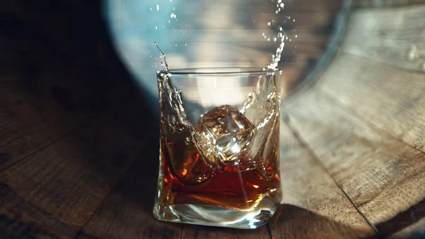 Kostka Ledu Padající Sklenice Whisky Dřevěném Sudu Koncept Nalévání Whisky — Stock fotografie