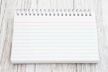 Boş çizgili not defteri, yıpranmış ahşap üzerine. Mesajınız için kopyalama alanı ile birlikte.