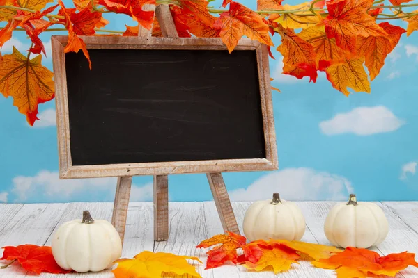 Blanco Staand Krijtbord Verweerd Hout Met Herfstbladeren Pompoenen Met Kopieerruimte — Stockfoto