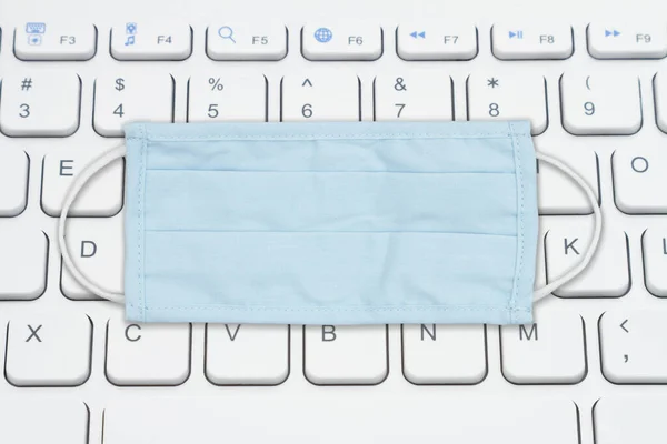 使用键盘和蓝色布面面具在网上找到你的Covid信息 — 图库照片