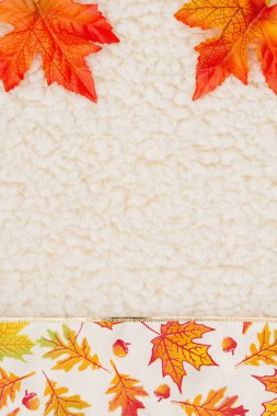 Kırmızı ve turuncu sonbahar mevsimlik mesajınız için bej şerpa malzemesi üzerinde sınır arkaplanı bırakır