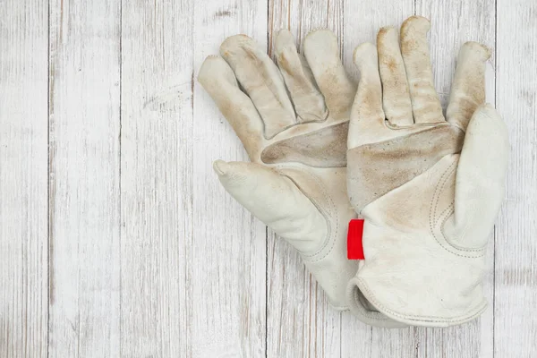 あなたの建設や庭の仕事のメッセージのための風化した木材上の汚れ覆われた革の作業手袋 — ストック写真