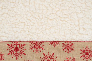 Red and brown snowflake border winter background on beige sherpa material for your xmas or winter message