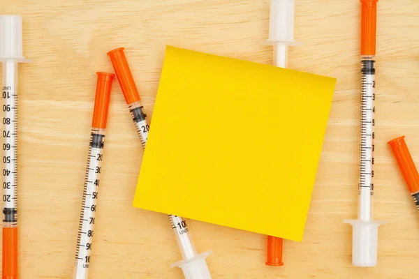 ワクチンまたはCovidメッセージのための付箋が付いた机の上の使い捨てワクチン針 — ストック写真